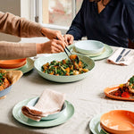 Two people sitting at a table with a meal in front of them, enjoying their time together.