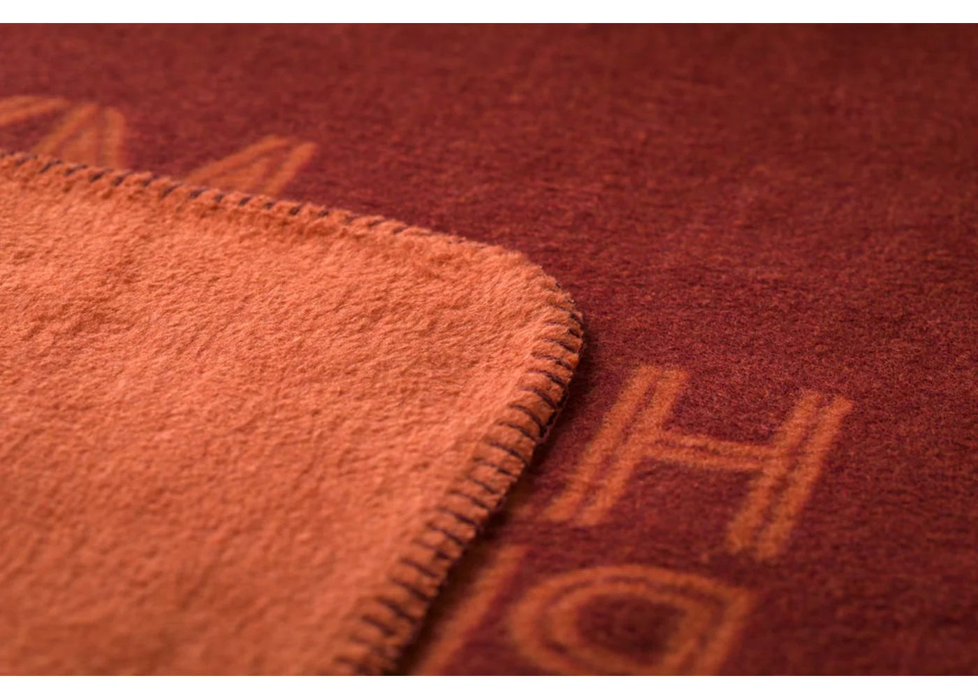 Close-up of a textured red fabric with visible stitching