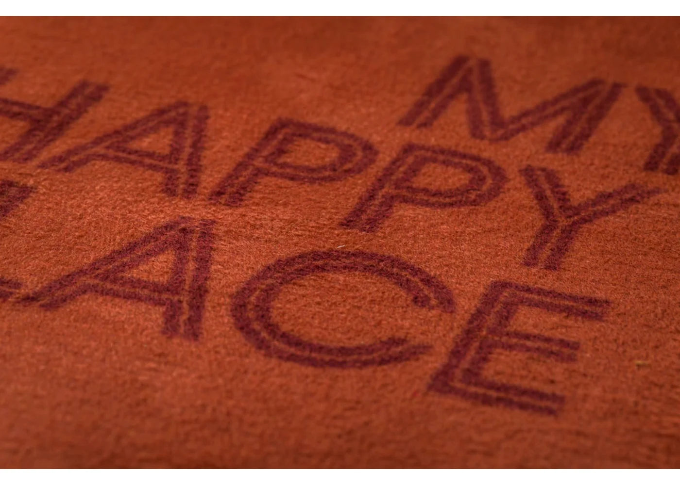 Brown throw with 'Happy Place' text on a brown background