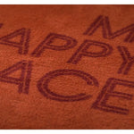 Brown throw with 'Happy Place' text on a brown background