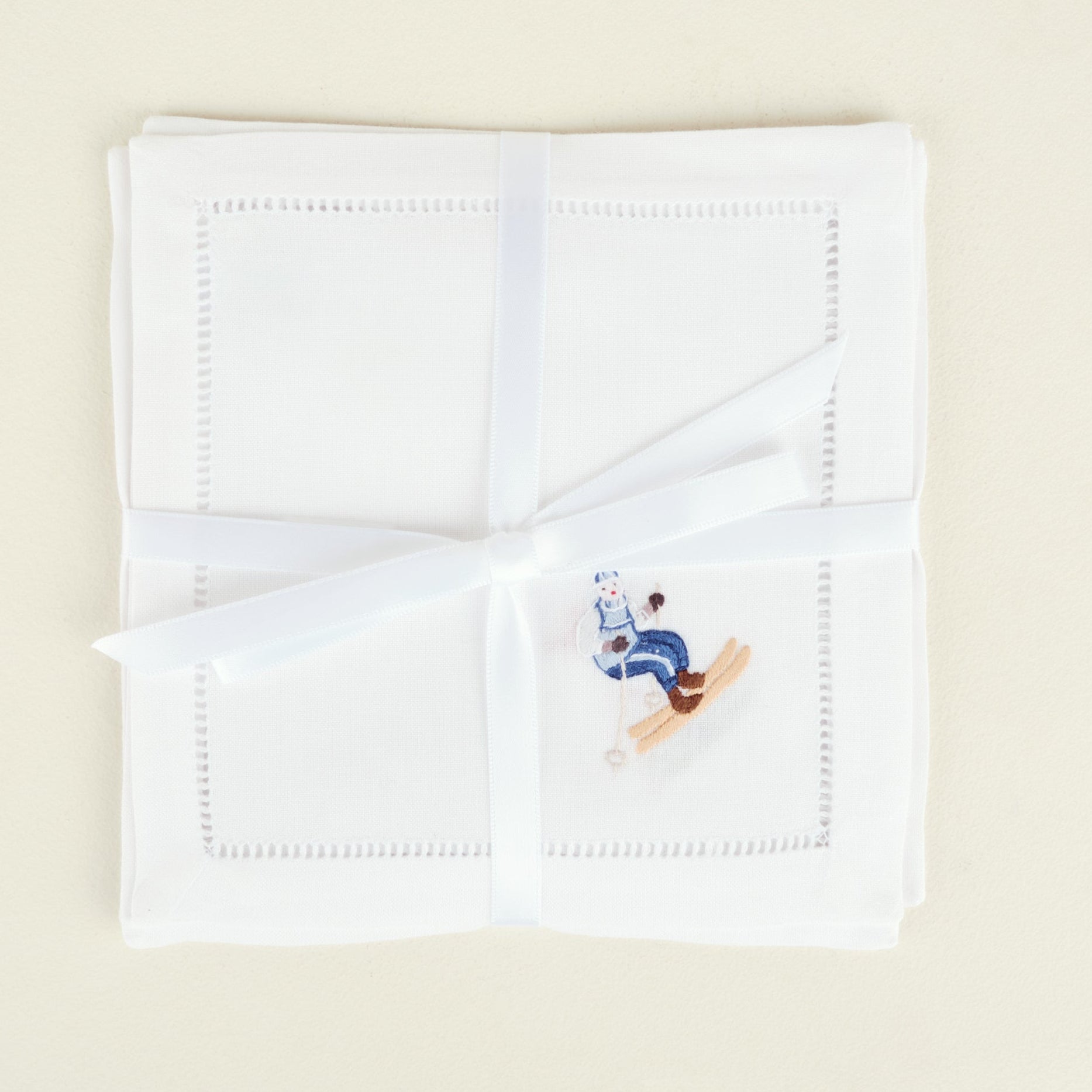White handkerchief with embroidered design on a beige background