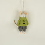 Small plush mouse toy wearing a green sweater and gray pants on a beige background