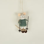 Small plush mouse toy on a swing against a plain background