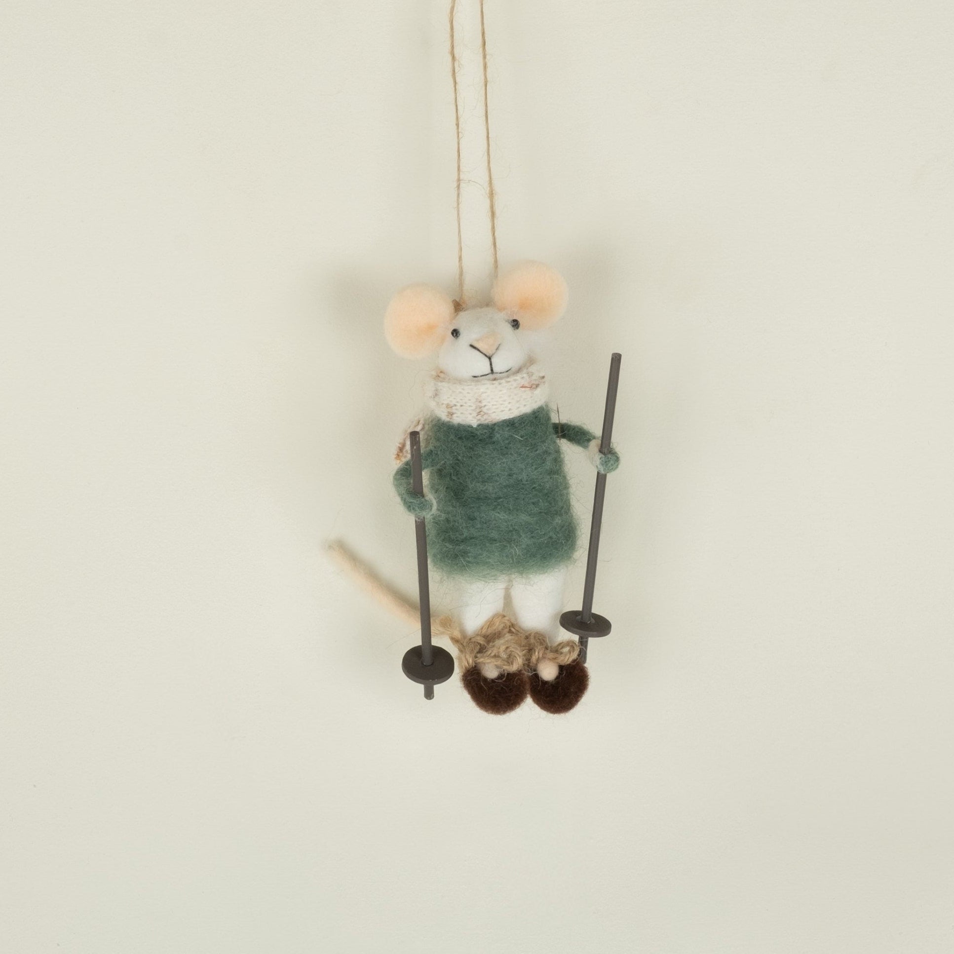 Small plush mouse toy on a swing against a plain background