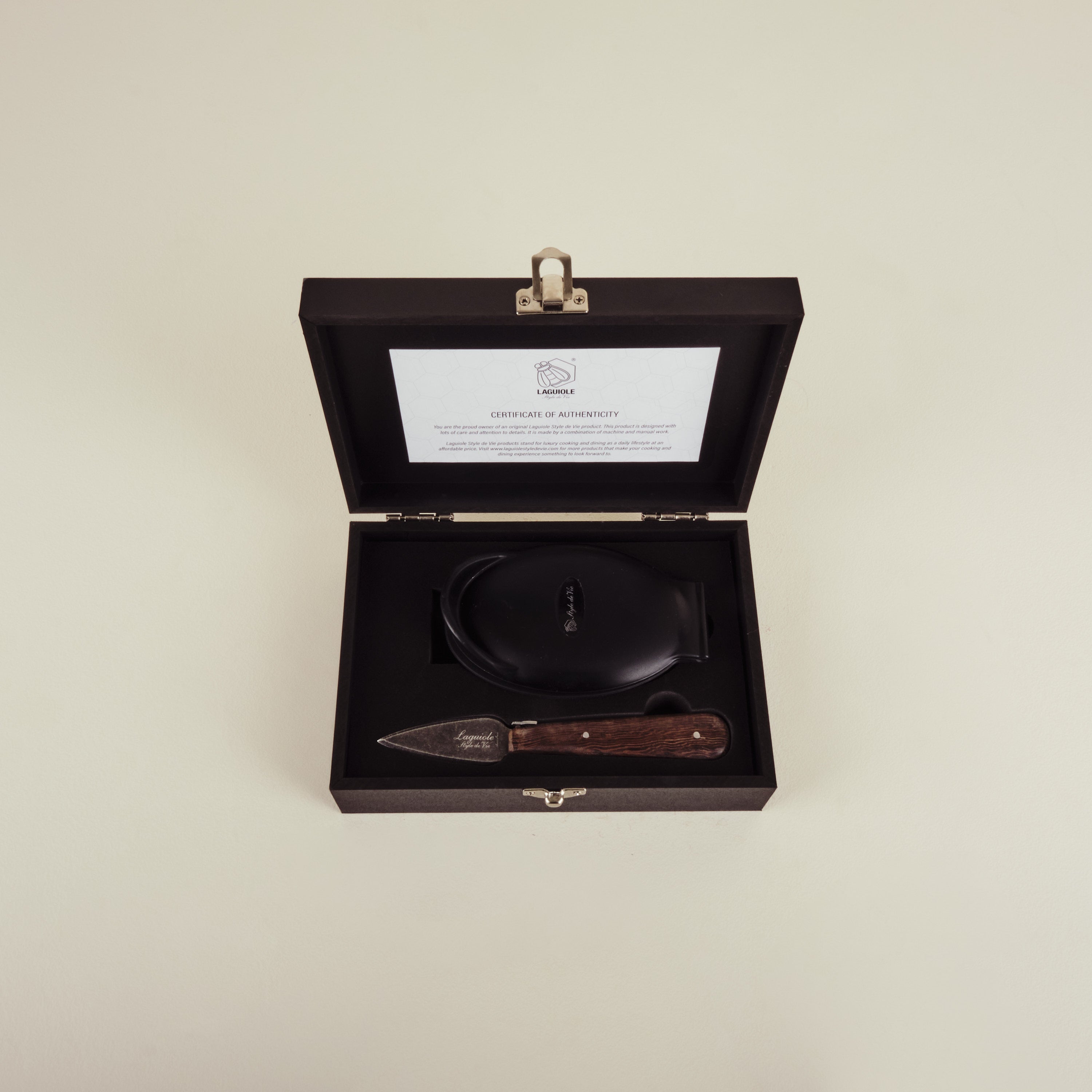 Set of knife and fork in a black box with a certificate of authenticity on a beige background