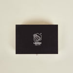 Black Laguiole knife set box on a beige background