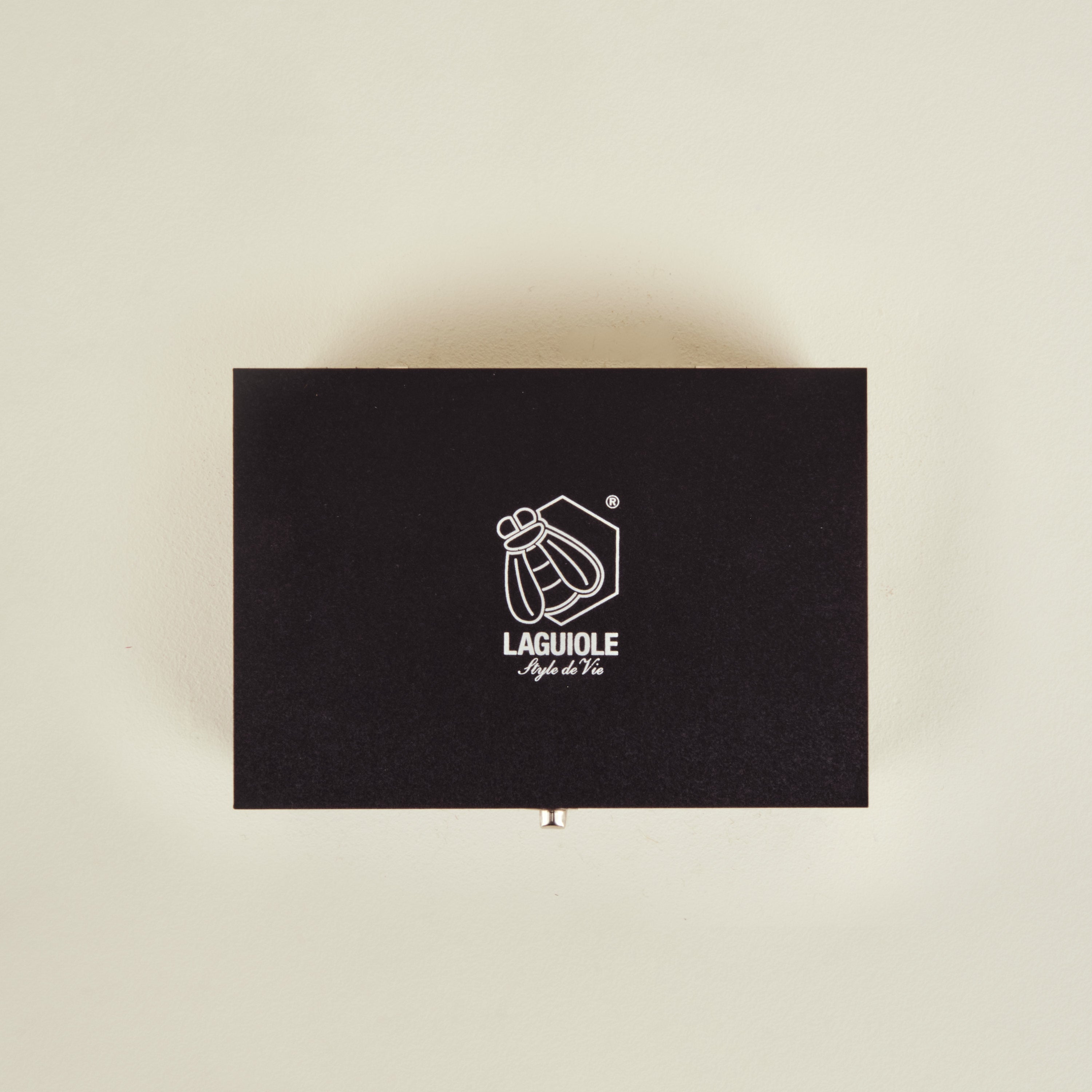 Black Laguiole knife set box on a beige background
