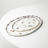 Decorative oval ceramic platter with floral patterns on a white surface