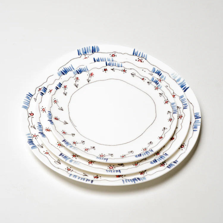 Set of three decorative ceramic plates with floral patterns on a white background