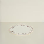 Round ceramic plate with floral patterns on a beige background