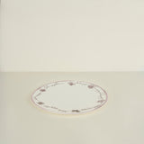 Round ceramic plate with floral patterns on a beige background