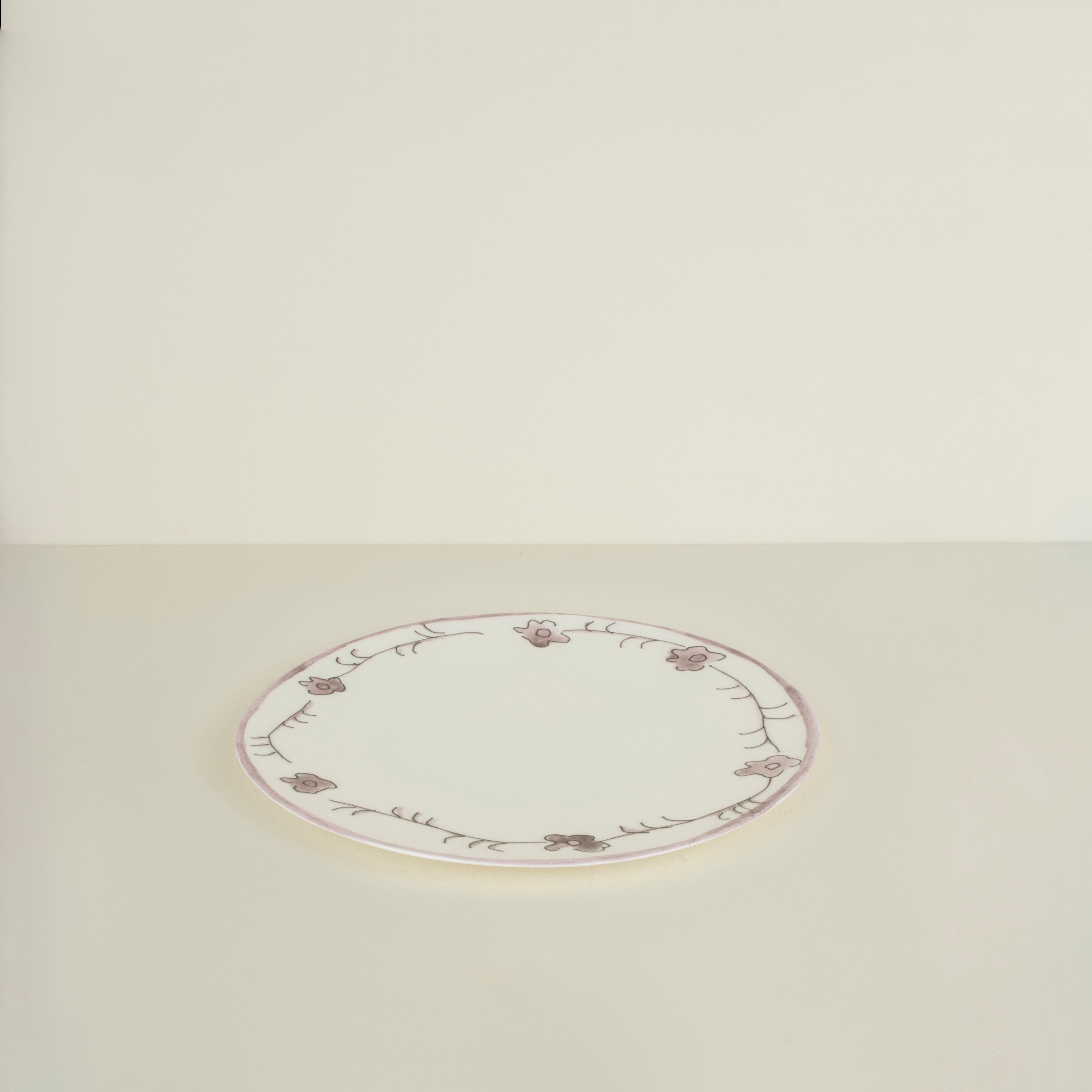 Round ceramic plate with floral patterns on a beige background