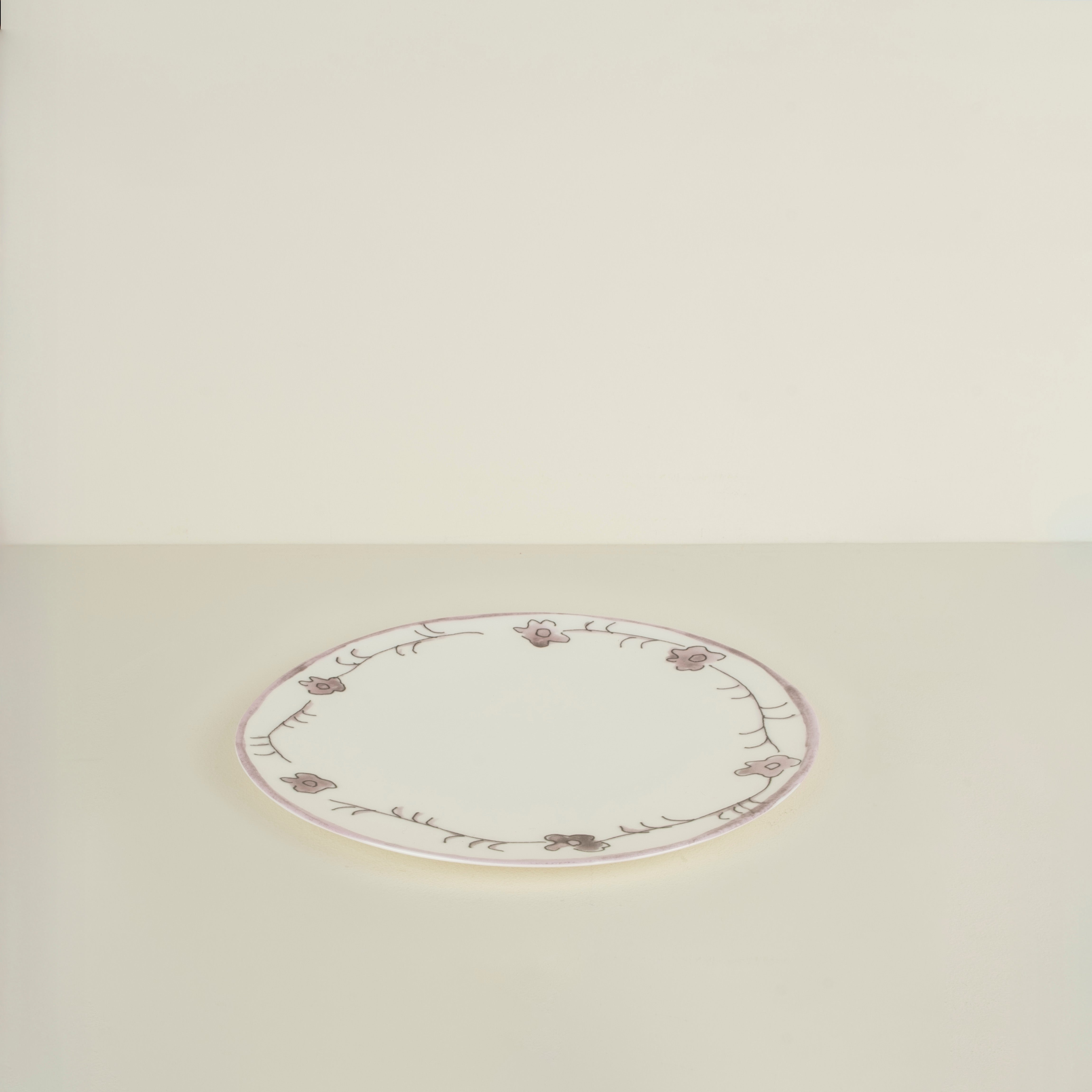 Round ceramic plate with floral patterns on a beige background