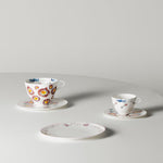 Two ceramic teacups with floral designs on a gray surface
