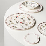 Set of ceramic plates with floral designs on a white surface
