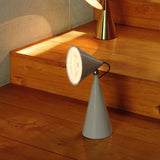 Modern table lamps on a wooden surface with a concrete wall background