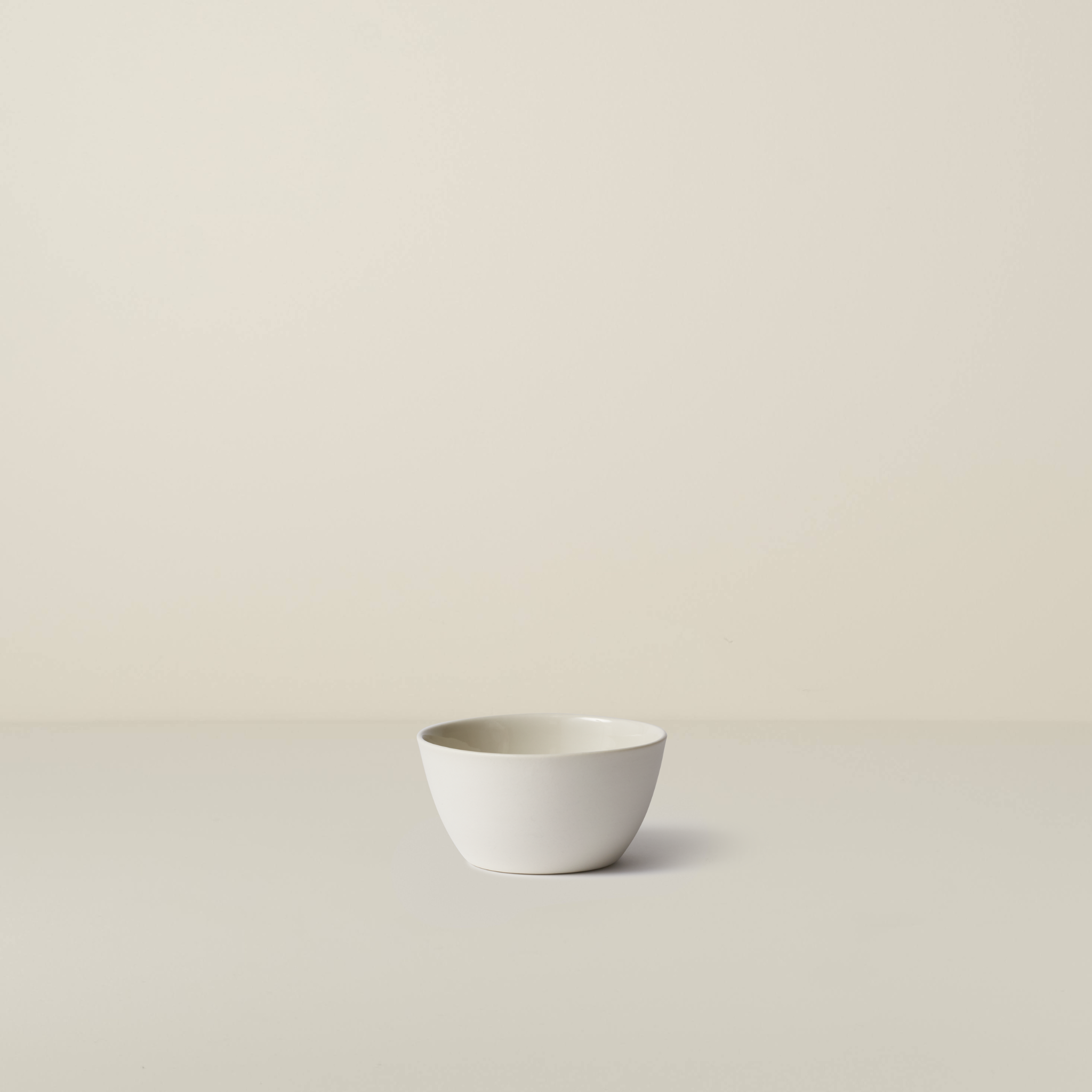 White ceramic bowl on a beige background
