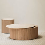 Three round wooden tables of varying sizes on a neutral background