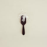 Black spoon with salt on a beige background