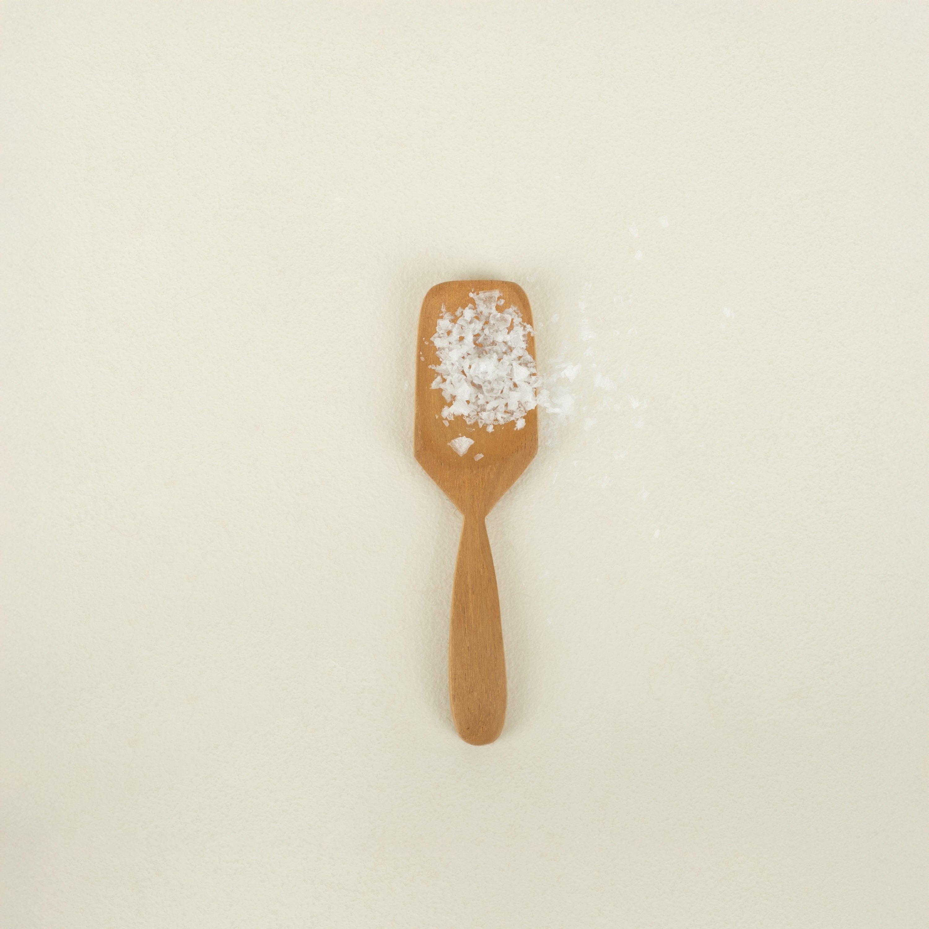 teak salt spoon holding salt