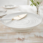 White ceramic platter with gold knife on a wooden table