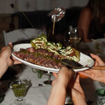 Person holding a plate with food, possibly at an event or gathering.