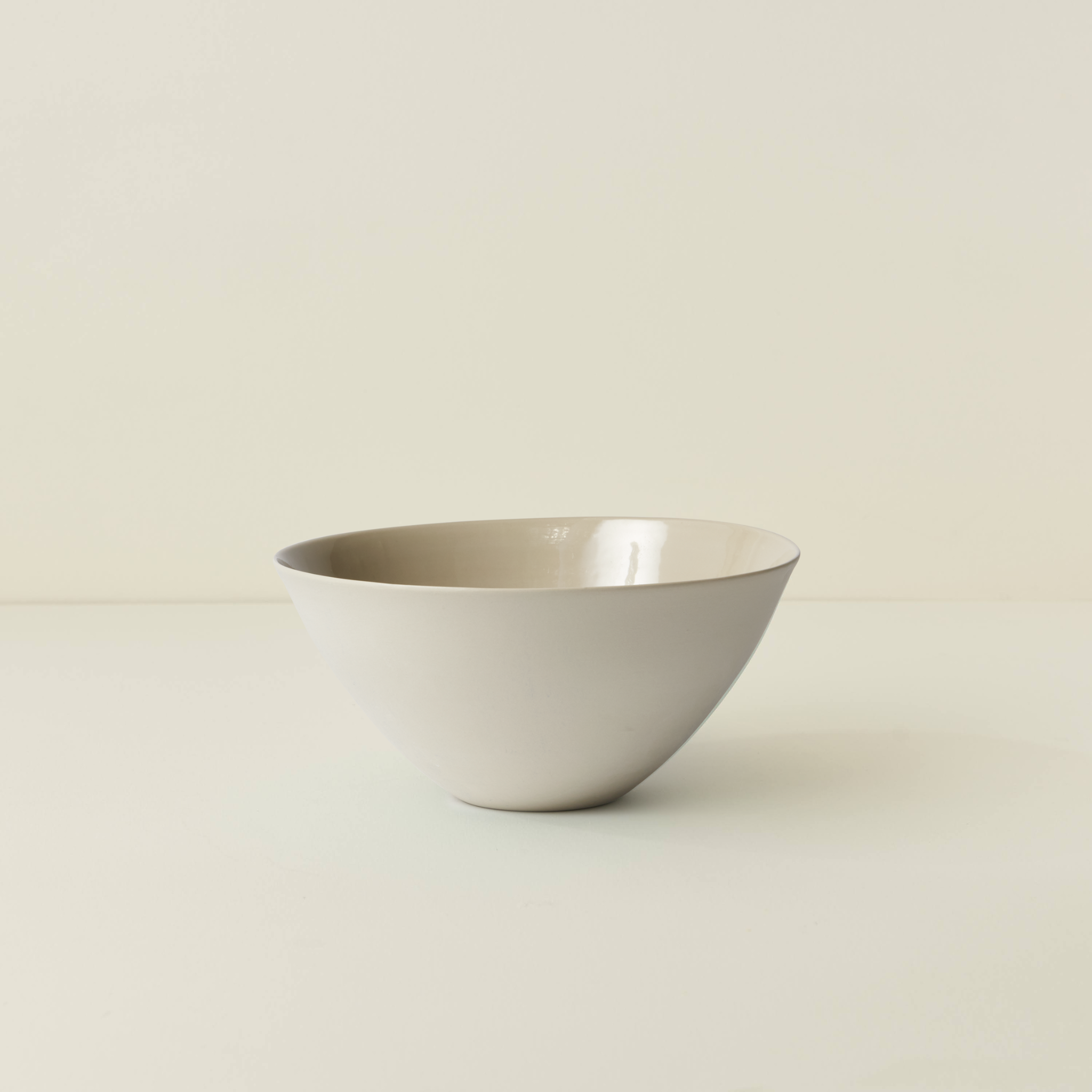 White ceramic bowl on a beige background