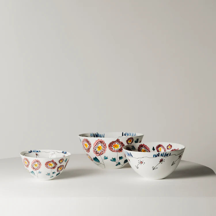 Set of four ceramic bowls with floral patterns on a light gray background