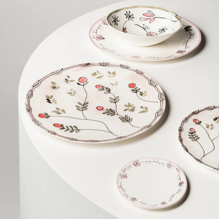 Set of ceramic plates with floral designs on a white surface
