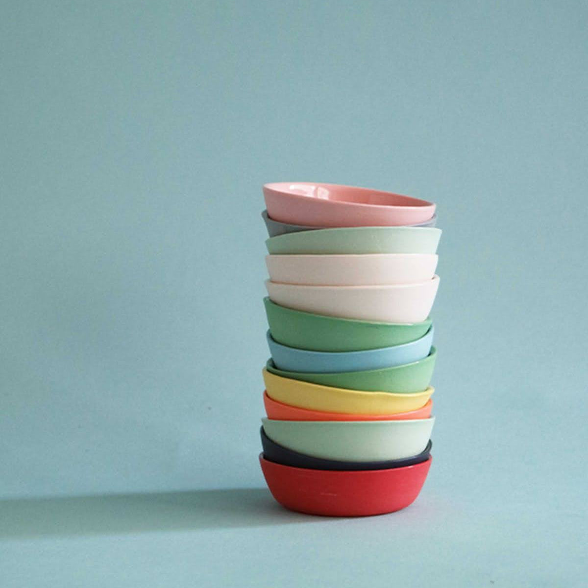 Stack of colorful ceramic bowls on a light blue background