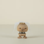 Small bride wooden figurine with a gold top on a beige background