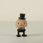 Small decorative wood groom figure with a top hat on a beige background