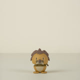 Small figurine of a lion character with brown hair and a yellow outfit on a beige background