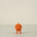 Small orange character on a beige background