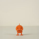 Small orange character on a beige background