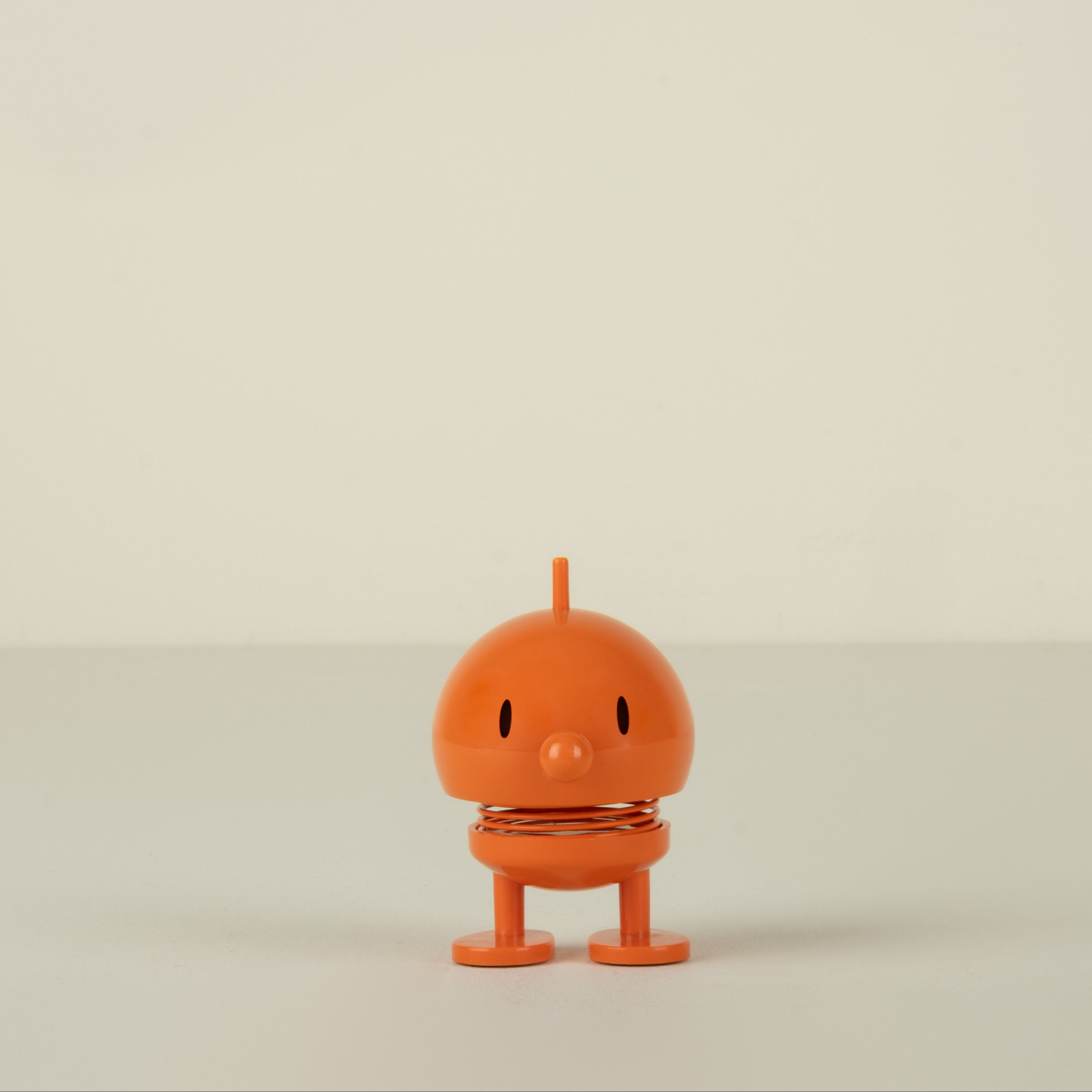 Small orange character on a beige background