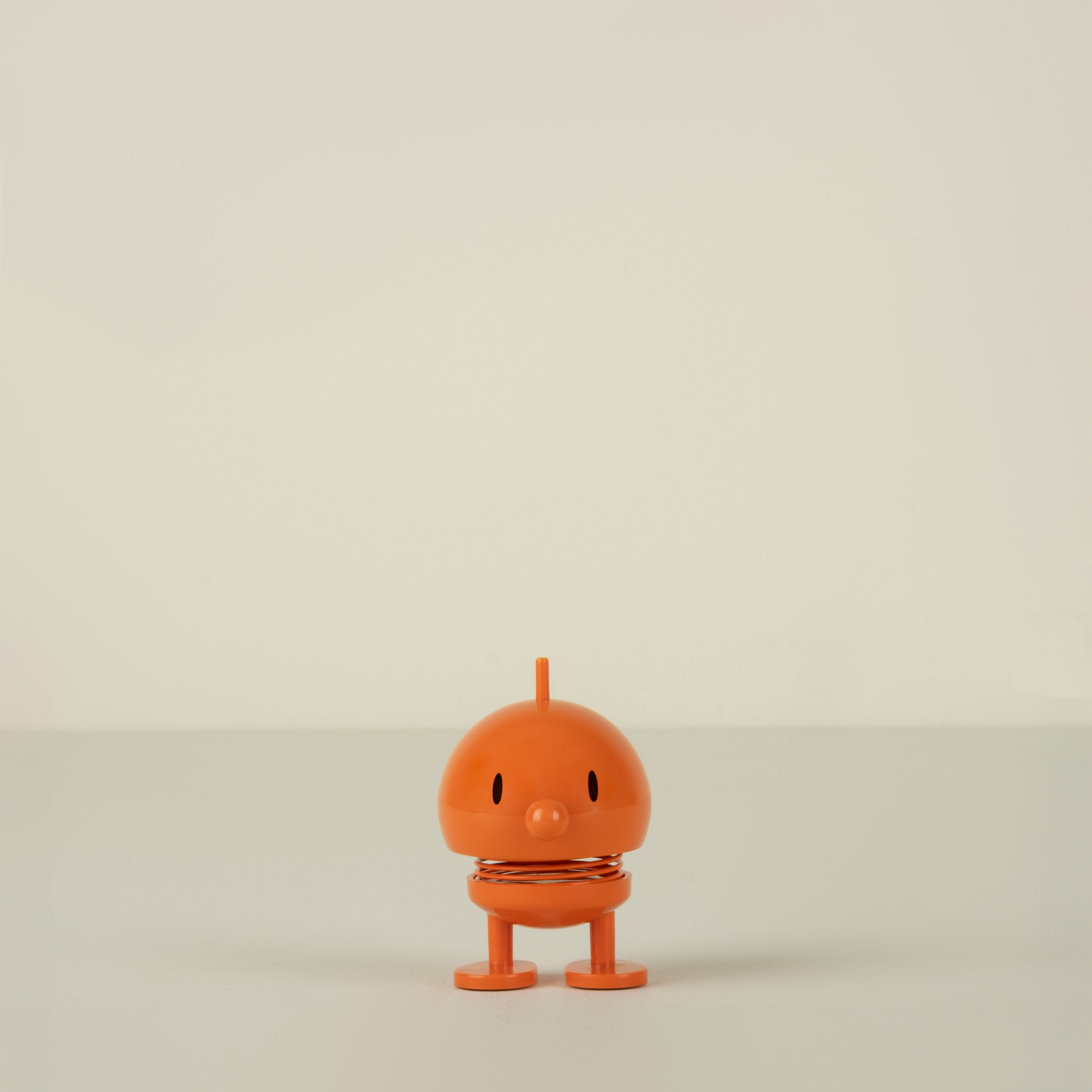 Small orange character on a beige background