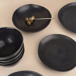 Set of black ceramic plates on a beige background