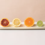 Sliced citrus fruits on a white tray with a neutral background