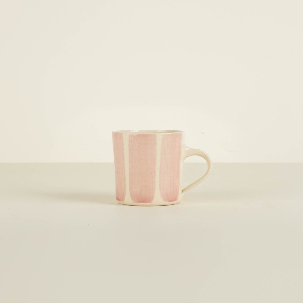 Pink ceramic mug on a beige background