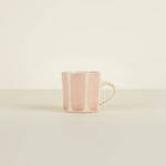 Pink ceramic mug on a beige background