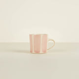 Pink ceramic mug on a beige background