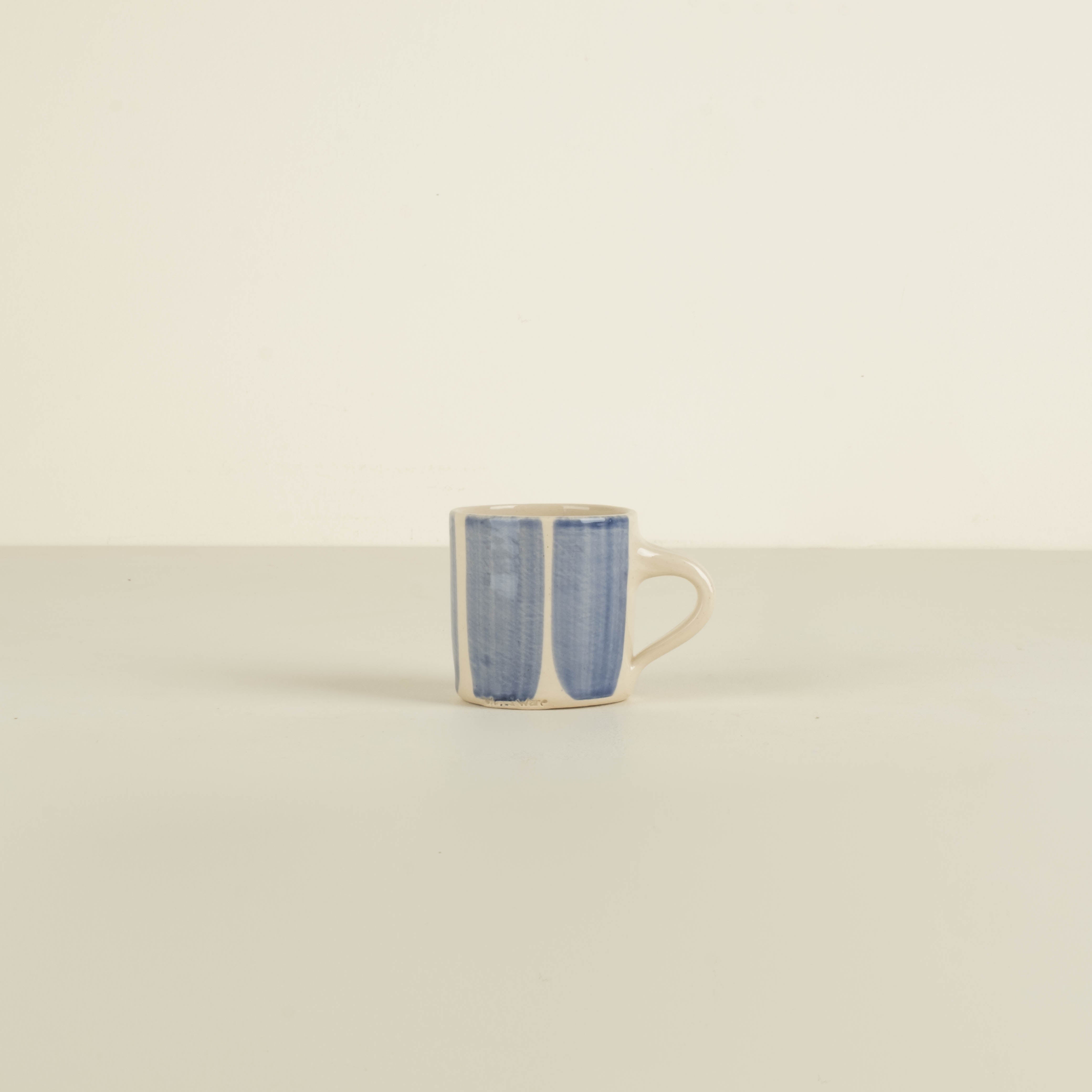 Ceramic mug with blue and white pattern on a beige background