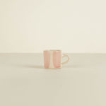 Pink ceramic mug on a beige background