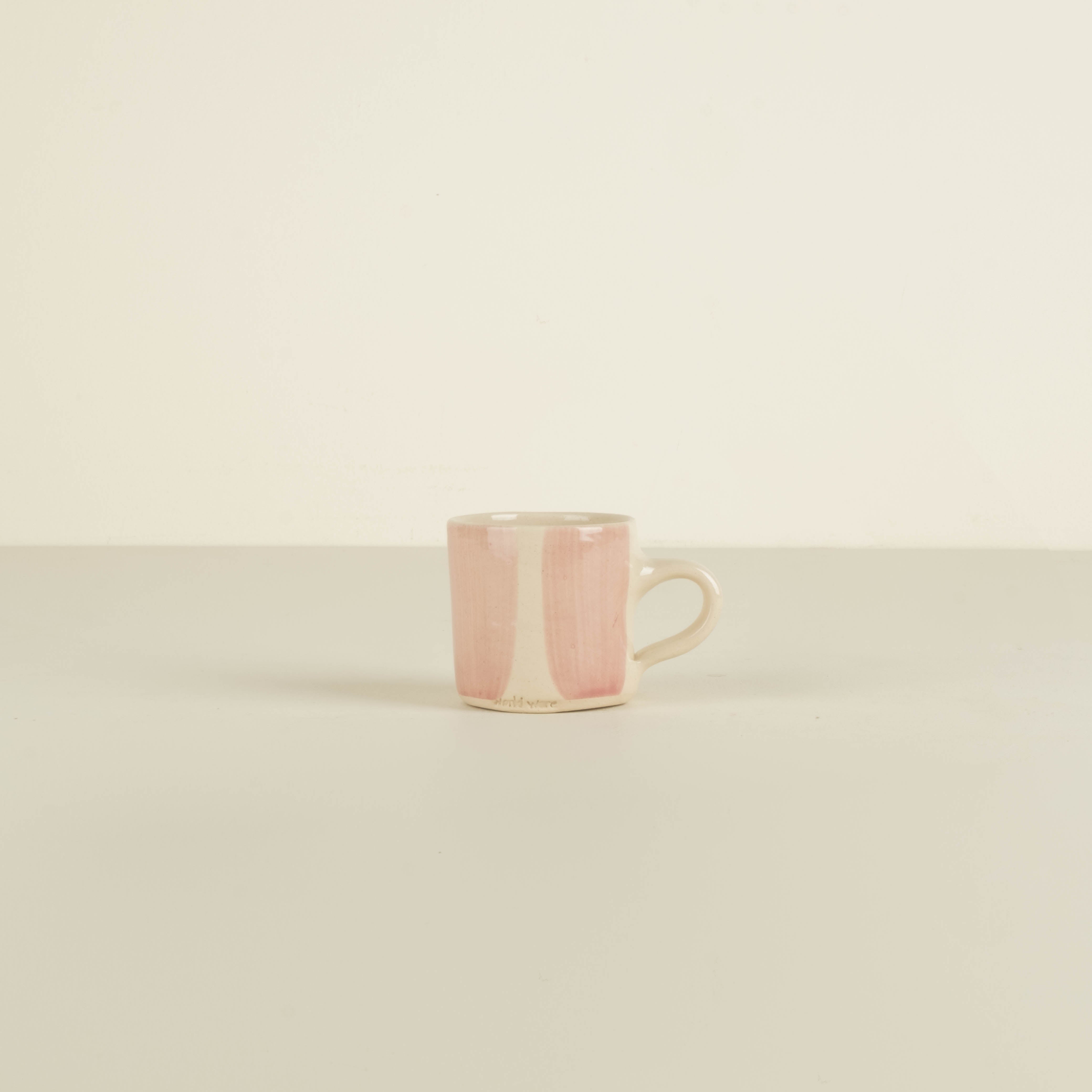 Pink ceramic mug on a beige background