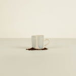 Ceramic mug with a light blue interior and beige exterior on a white background