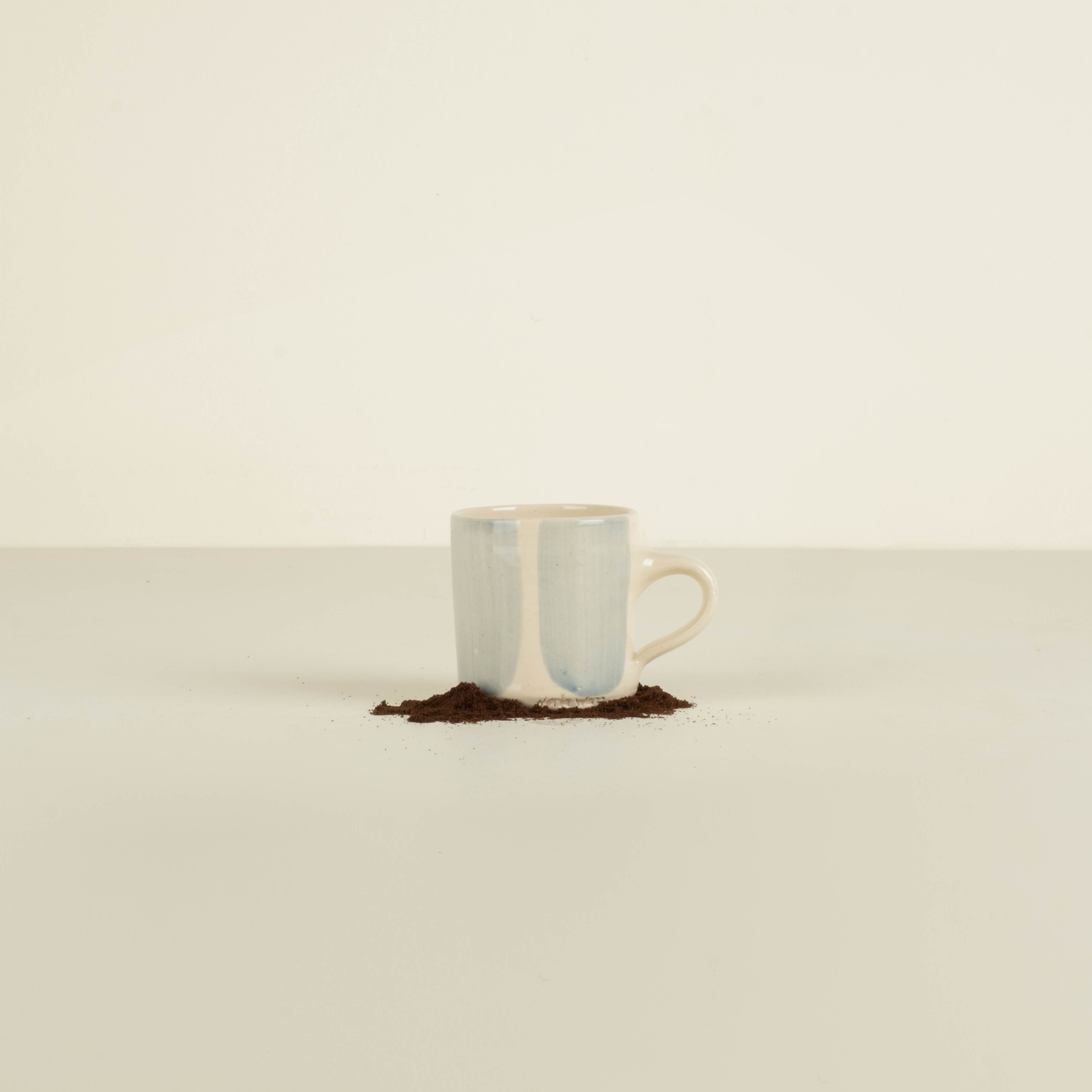 Ceramic mug with a light blue interior and beige exterior on a white background