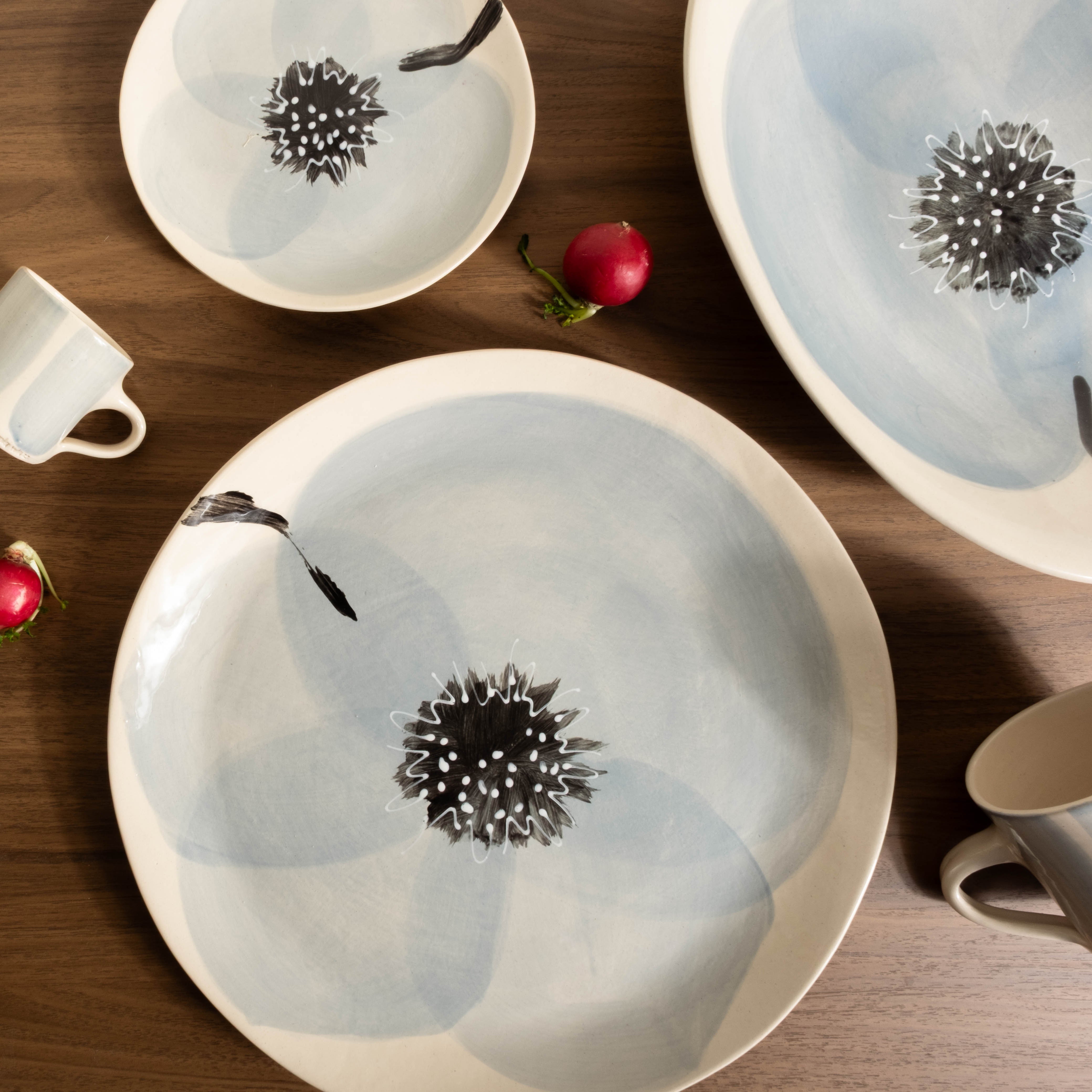 Set of ceramic plates with floral designs on a wooden table.