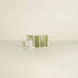 Ceramic cup with green stripes on a white surface