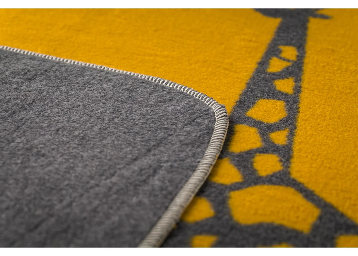 Close-up of a yellow and gray textured blanker with a geometric pattern.